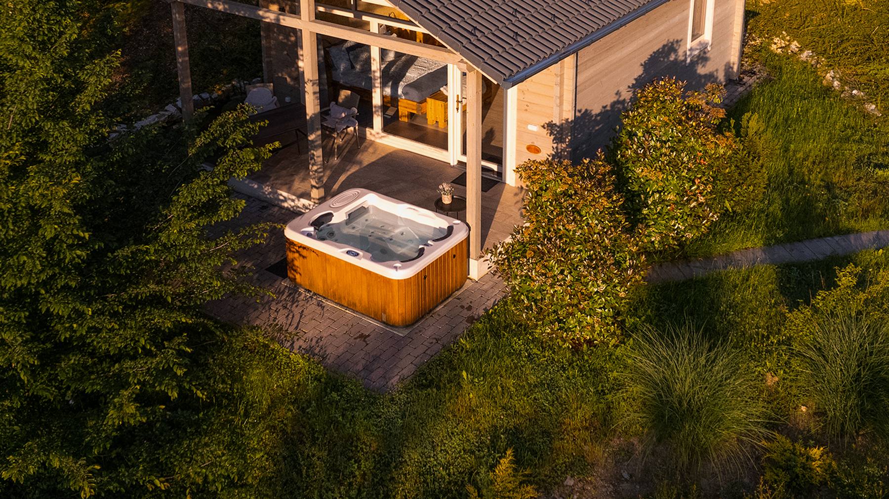 Faház teraszán álló VitalSpa jakuzzi, alkonyi fényben