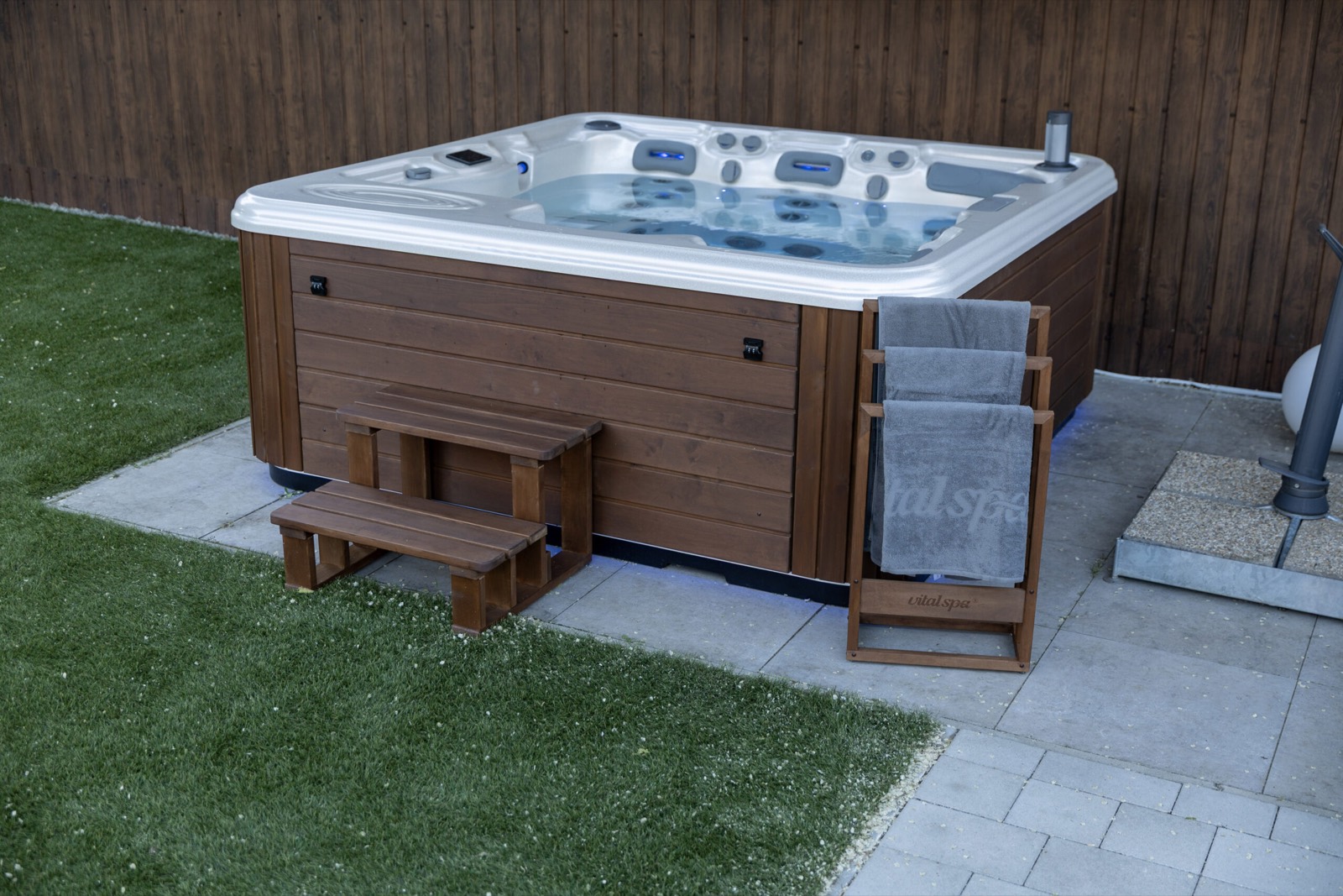 Beépített VitalSpa jakuzzi kertben, thermowood burkolattal, lépcsővel és törölközőtartóval